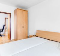 Ein Doppelzimmer mit Holzelementen und einem Schrank in einer Zweizimmerwohnung.