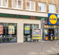 Lidl in der Grösslingova-Straße in Bratislava - Altstadt mit vorbeigehenden Menschen und einem Fahrrad.