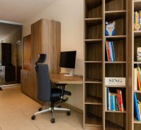Bücherschrank und Arbeitsecke mit Stuhl in einer 2-Zimmer-Wohnung mit Blick auf den Balkon.