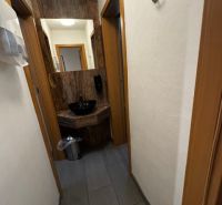 Der Flur der Geschäftsräume mit dunklem Boden und weißen Wänden.