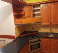 Küche in einer 3-Zimmer-Wohnung mit Holzschränken und Keramikfliesen.