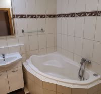 Badezimmer mit Badewanne und Waschbecken, helle Fliesen in einer 3-Zimmer-Wohnung.