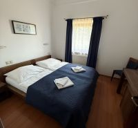 Ein Zimmer mit Doppelbett, blauer Bettdecke und Holzboden in Hotels und Pensionen.