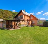Ein Einfamilienhaus in Dolná Mariková mit Rasen und Pavillon in einer natürlichen Umgebung.