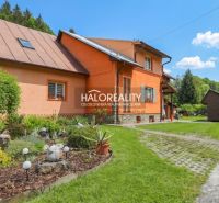Ein Einfamilienhaus in Dolná Mariková mit einer bunten Fassade, umgeben von einem grünen Garten und einem Gehweg.