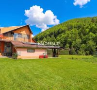 Ein Einfamilienhaus in Dolná Mariková mit Rasen und umliegendem Grün.