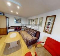 Wohnzimmer in einem Einfamilienhaus mit Sofa, Holzboden und Wandbildern.