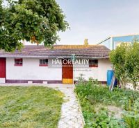 Ein Einfamilienhaus in Senica mit Garten, Bäumen und einem Gartenhaus.
