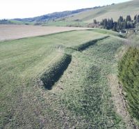 Grüne landwirtschaftliche und forstwirtschaftliche Flächen in Čierny Balog mit hügeliger Landschaft und Bäumen.