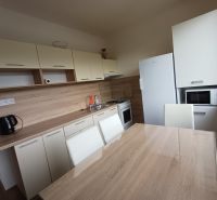 Küche mit Holzboden und Esstisch in einer 3-Zimmer-Wohnung.