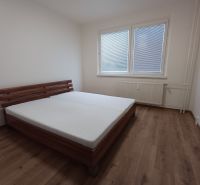 Schlafzimmer mit Bett und Holzboden in einer 3-Zimmer-Wohnung.