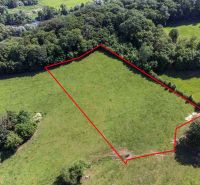 Luftaufnahme von Erholungsgrundstücken in Ostrá Lúka mit Wald im Hintergrund.