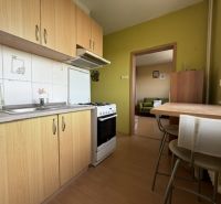 Küche in einer Einzimmerwohnung mit Holzboden, Esstisch und Ausstattung.