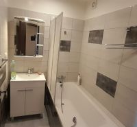 Badezimmer in einer 2-Zimmer-Wohnung mit Badewanne und Waschtischunterschrank.