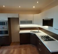 Küche in einer 2-Zimmer-Wohnung mit Holzboden und eingebauten Geräten.