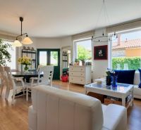 Wohnzimmer in einem Einfamilienhaus mit Holzboden, Sitzecke und Tisch.