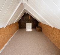 Dachboden der Hütte mit Holzeinrichtung und einem Rattankorb zur Aufbewahrung.