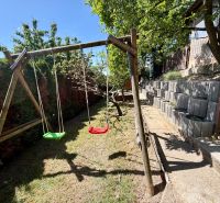 Holzschaukeln im Hof der Hütte in Kunov, Senica, mit terrassenförmiger Gartengestaltung.