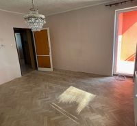 Wohnzimmer in einer 3-Zimmer-Wohnung mit Holzboden und Kronleuchter.