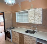 Küche in einer 3-Zimmer-Wohnung mit Gasherd, Fliesenboden und gemusterten Küchenschränken.