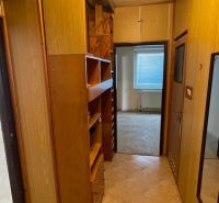 Der Flur in der 3-Zimmer-Wohnung mit Holzmöbeln und hellem Boden.