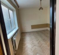 Ein Zimmer in einer 3-Zimmer-Wohnung mit einem Boden in Holzoptik und einem Fenster an der Wand.