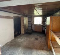 Garage mit Regalen, Betonboden, kleines Fenster, Stauraum.