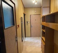 Flur in einer 3-Zimmer-Wohnung mit Fliesenboden und Regalen an der Wand.