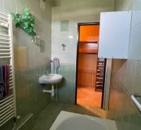 Badezimmer mit grünen Fliesen und Schrank in einer 3-Zimmer-Wohnung.