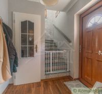 Eingangshalle mit Holztüren, Boden mit Holzdekor und Treppe in einem Einfamilienhaus.