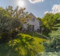 Ein Einfamilienhaus in Bernolákovo, umgeben von einem üppigen Garten auf einem sonnigen Grundstück.