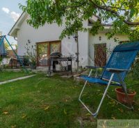 Der Garten eines Einfamilienhauses in Bernolákovo mit einer Schaukel, Gartenmöbeln und Grünflächen.
