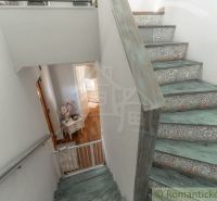 Treppe im Einfamilienhaus mit dekorativen Mustern und einem Boden in Holzoptik.