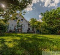 Ein Einfamilienhaus in Bernolákovo, umgeben von einem Garten mit Grünflächen und Bäumen.