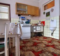 Küche in einem Einfamilienhaus mit Teppich, Esstisch und Gasherd.