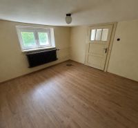 Ein Zimmer im Einfamilienhaus hat einen Boden mit Holzdekor und weiße Wände.
