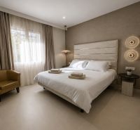 Schlafzimmer in einer 4-Zimmer-Wohnung mit Doppelbett, hellem Boden und neutralen Vorhängen.
