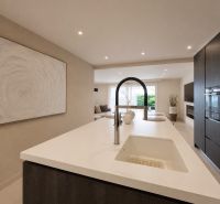 Eine Küche in einer 4-Zimmer-Wohnung mit einer Insel und eingebauten Geräten.