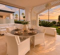 Die Terrasse einer 4-Zimmer-Wohnung mit Meerblick, bequemen Sitzgelegenheiten und elegantem Essbereich.