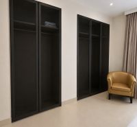In der 4-Zimmer-Wohnung befinden sich ein schwarzer Schrank und ein beiger Sessel.