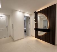 Flur in einer 4-Zimmer-Wohnung, elegante Möbel mit Beleuchtung und Designelementen an der Wand.