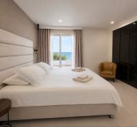 Schlafzimmer in einer 4-Zimmer-Wohnung mit Meerblick, mit einem bequemen Bett und einem Schrank.