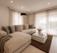 Helles Wohnzimmer in einer 4-Zimmer-Wohnung mit einem bequemen Sofa und einem Couchtisch.