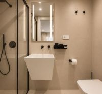 Badezimmer mit Duschkabine, Spiegel und Hängewaschbecken in einer 4-Zimmer-Wohnung.