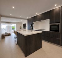 Küche in einer 4-Zimmer-Wohnung mit dunklen Schränken und offenem Raum zum Wohnzimmer.
