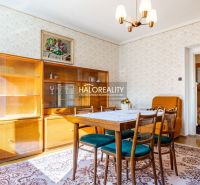 Esszimmer in einem Einfamilienhaus mit Holzmöbeln, Tapeten und Licht von einem Kronleuchter.
