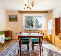 Esszimmer in einem Einfamilienhaus mit Teppichboden, Holzmöbeln und einem Tisch mit Stühlen.