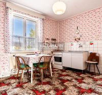 Küche in einem Einfamilienhaus mit bunten Tapeten, Tisch und Herd.