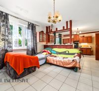 Wohnzimmer mit großem Fenster, ausziehbarem Sofa und Küchenzeile in einem Einfamilienhaus.