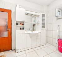 Badezimmer in einem Einfamilienhaus mit weißen Möbeln und einer Waschmaschine.